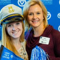 Two alumni pose with GV props